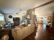 Open-concept living room featuring hardwood flooring, a stone fireplace, and stylish furnishings at 110 N River Rd, Mcdonough, GA 30252