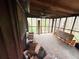 Sunroom with exposed ceiling beams, screened windows offering wooded views, and unfinished flooring at 110 N River Rd, Mcdonough, GA 30252
