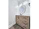 Modern bathroom featuring wood cabinet and drawers with a round mirror above a marble sink at 2000 Grove Ave, East Point, GA 30344