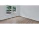 Bright bedroom featuring hardwood floors, white walls, and a large window for natural light at 2000 Grove Ave, East Point, GA 30344