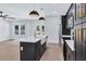 Modern kitchen with white counters, black cabinets, stainless appliances, hardwood floors, and modern lighting at 2000 Grove Ave, East Point, GA 30344