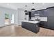 An open kitchen features stylish cabinets, a modern island, stainless steel appliances and access to the backyard at 2000 Grove Ave, East Point, GA 30344