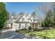Side view of white brick home, showcasing three-car garage, and manicured lawn at 3224 Lanier Ne Dr, Atlanta, GA 30319