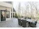 Inviting outdoor patio featuring a dining table, wicker chairs, and serene wooded views at 3224 Lanier Ne Dr, Atlanta, GA 30319