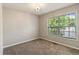 Cozy bedroom with neutral carpet and a large window offering natural light and outdoor views at 6983 Pine Shadow Way, Winston, GA 30187