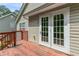 Wooden deck featuring a set of double doors, offering a welcoming outdoor space for relaxation at 6983 Pine Shadow Way, Winston, GA 30187