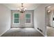 Cozy dining room featuring carpet, a chandelier, and bright natural light from the large windows at 6983 Pine Shadow Way, Winston, GA 30187