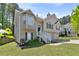 Charming two-story home with tan siding, an arched entryway, manicured lawn, and lush landscaping at 6983 Pine Shadow Way, Winston, GA 30187