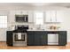 Modern kitchen featuring stainless steel appliances, white countertops, and dark blue cabinets at 91 Chester Se Aly, Atlanta, GA 30316