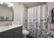 Bathroom featuring a shower-tub combo with a floral shower curtain, blue-grey vanity and chrome fixtures at 138 Elysian Nw Way, Atlanta, GA 30327