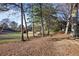 Backyard view featuring a sloping hill, large trees and view of the golf course at 138 Elysian Nw Way, Atlanta, GA 30327