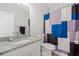 Well-lit bathroom showcasing a granite vanity and a shower with a colorful curtain at 2105 Rotunda Ct, Conyers, GA 30094