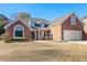 Charming two-story brick home featuring an attached garage and manicured front yard at 2105 Rotunda Ct, Conyers, GA 30094