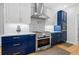 Modern kitchen with stainless steel appliances, range hood and elegant white and blue cabinets at 2105 Rotunda Ct, Conyers, GA 30094