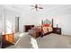 Large main bedroom with neutral carpet, tray ceiling, and a decorative metal bed frame at 2105 Rotunda Ct, Conyers, GA 30094