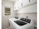Functional laundry room featuring modern washer and dryer units with overhead storage at 3021 Favor Pines Sw Ct, Marietta, GA 30060