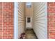 Narrow home entryway with brick wall and wood siding leading up to a white front door at 875 Edgewater Cir, Marietta, GA 30062