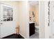 Hallway view leading to a half bathroom with a dark wood vanity and tiled floors at 875 Edgewater Cir, Marietta, GA 30062
