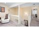 Upstairs landing featuring a comfortable white chair, neutral carpet, and natural light at 875 Edgewater Cir, Marietta, GA 30062