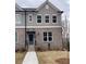 Charming townhouse featuring a brick facade, gray siding, and a well-manicured front lawn at 1250 Ainsworth Aly # 42, Sugar Hill, GA 30518