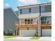 Exterior of the gray townhome featuring a garage and upper level wood balcony at 1250 Ainsworth Aly # 42, Sugar Hill, GA 30518