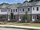 Modern townhomes featuring brick and siding exteriors with well-kept lawns at 1250 Ainsworth Aly # 42, Sugar Hill, GA 30518