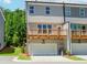 Exterior of the gray townhome featuring a garage and upper level wood balcony at 1250 Ainsworth Aly # 42, Sugar Hill, GA 30518