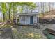 Small outdoor building featuring a service window and door nestled in a wooded backyard setting at 2887 Swarthmore Dr, Lawrenceville, GA 30044