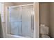 This bathroom features a shower-tub combo with sliding glass doors, next to a standard white toilet at 2887 Swarthmore Dr, Lawrenceville, GA 30044