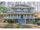 Charming two-story home with a welcoming front porch and blue accents, nestled among trees at 2887 Swarthmore Dr, Lawrenceville, GA 30044