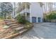 View of the side of the house, showcasing a two-car garage and a walkway with landscape lighting at 2887 Swarthmore Dr, Lawrenceville, GA 30044