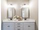 Bathroom featuring dual sinks, framed mirrors, modern lighting, and white countertops at 939 Jean Ct, Covington, GA 30014