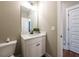 A half bath features a white vanity, framed mirror, modern lighting, and neutral wall color at 939 Jean Ct, Covington, GA 30014