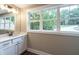 Bright bathroom with vanity, mirror, and large window with wooded view at 939 Jean Ct, Covington, GA 30014