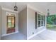 Inviting front porch features a stained wood door and stylish hanging lanterns at 939 Jean Ct, Covington, GA 30014