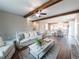 Open concept living room showcasing wood beams, modern furnishings, and a view into the kitchen at 939 Jean Ct, Covington, GA 30014