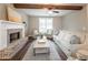 Bright living room with a brick fireplace, exposed beams, and stylish decor at 939 Jean Ct, Covington, GA 30014