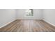Bedroom with wood flooring, white trim, and natural light from a window at 1590 Highland Farm Dr, Suwanee, GA 30024