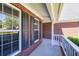 Close up view of a porch with red brick, white trim, and lots of natural light at 1590 Highland Farm Dr, Suwanee, GA 30024