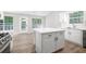 Kitchen boasting island, stainless steel appliances, white cabinetry, a pantry and laminate floors at 1590 Highland Farm Dr, Suwanee, GA 30024