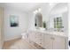 Well-lit bathroom features a double vanity with gold fixtures, dual mirrors, and hardwood floors at 3407 Deerwood Ct, Rex, GA 30273