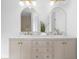 Bathroom vanity featuring double sinks, marble countertops, arched mirrors, and gold fixtures at 3407 Deerwood Ct, Rex, GA 30273