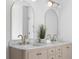 Double vanity with marble countertops, gold fixtures, and arched mirrors at 3407 Deerwood Ct, Rex, GA 30273