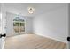 A bedroom with light-colored hardwood floors and a window offering a view of the neighborhood at 3407 Deerwood Ct, Rex, GA 30273