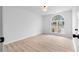 A bedroom featuring hardwood floors, a window overlooking the outdoors, and white walls at 3407 Deerwood Ct, Rex, GA 30273