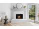 Cozy fireplace with white painted brick, white mantle and a large window with green view at 3407 Deerwood Ct, Rex, GA 30273