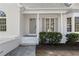 Inviting front porch with gray door, pillars and manicured shrubbery at 3407 Deerwood Ct, Rex, GA 30273
