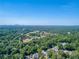 An aerial view of a community nestled amongst a vibrant green landscape with a city skyline in the distance at 4590 Lake Forrest Nw Dr, Atlanta, GA 30342