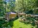 Aerial view of the expansive brick home showcasing its spacious yard and wooded surroundings at 4590 Lake Forrest Nw Dr, Atlanta, GA 30342