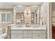 Stylish bathroom featuring double sinks, marble countertop, decorative wallpaper, and ample storage space at 4590 Lake Forrest Nw Dr, Atlanta, GA 30342